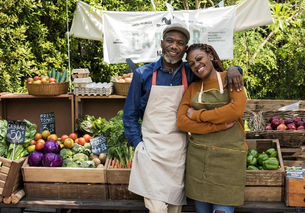 Black farmers standing proudly at their produce market